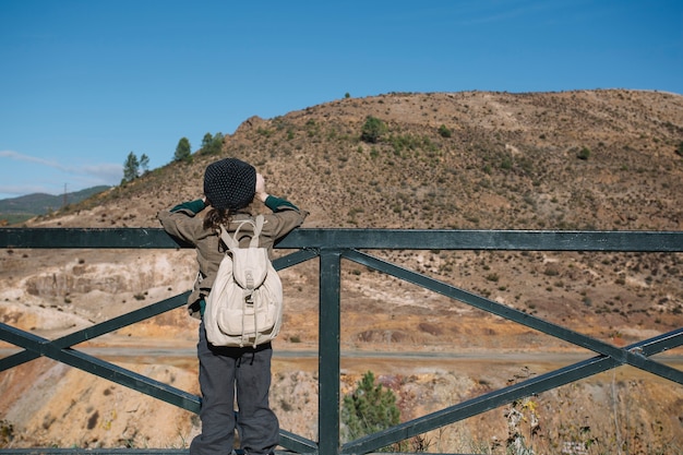 Boy with backpack looking at hill