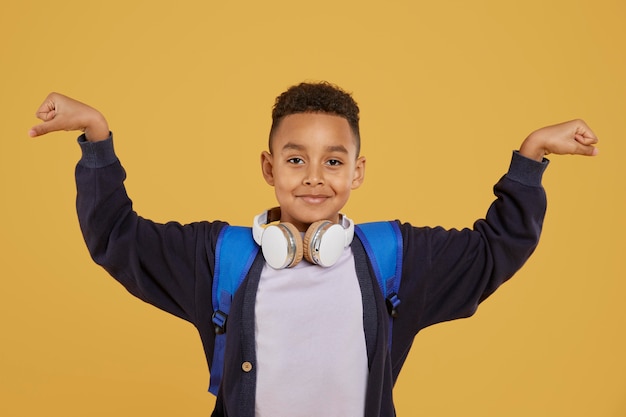 Boy with blue backpack showing muscles