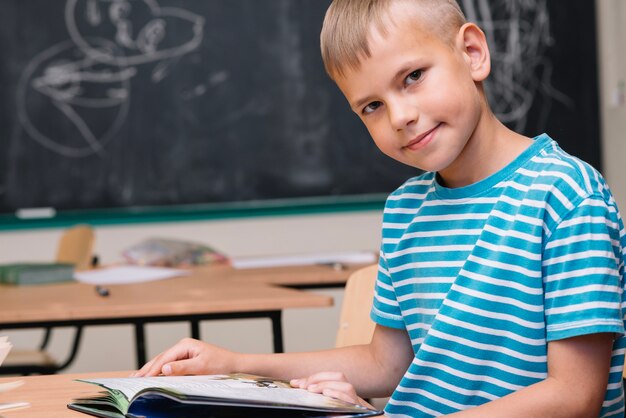 Boy with book looking at camera