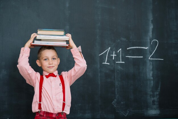 Boy with books stack on head