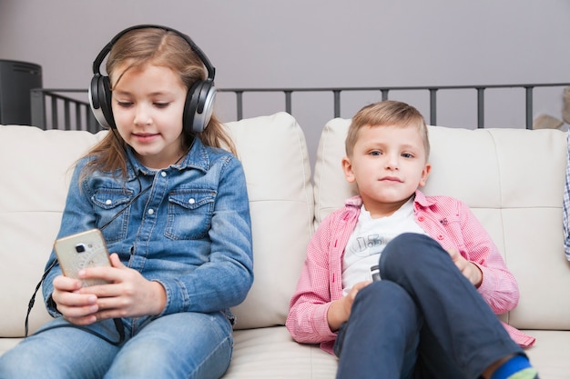 Boy with controller and girl with smartphone