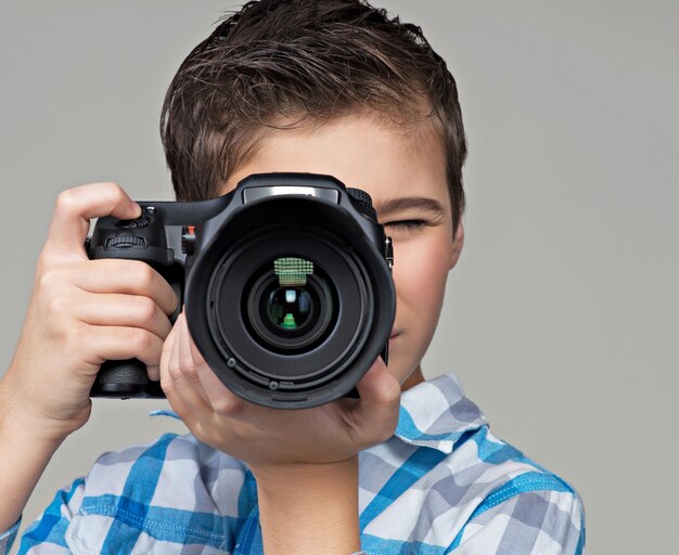 Boy  with dslr camera photographing.  Teen  boy with camera taking pictures.
