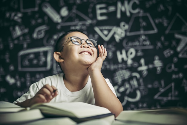 Free photo a boy with glasses man writing in the classroom