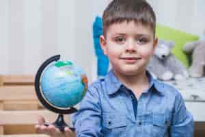 Foto gratuita ragazzo con il globo in mano