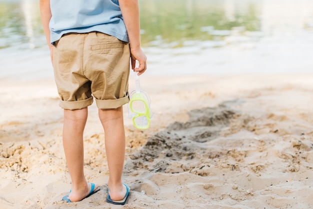 Boy with goggles looking at water