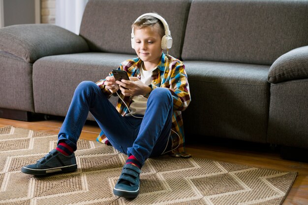 Boy with headphones using smartphone