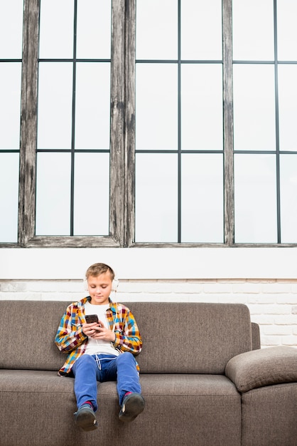 Boy with headphones using smartphone