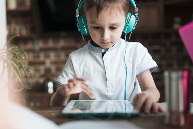 タブレットを使ったヘッドホンを持つ少年