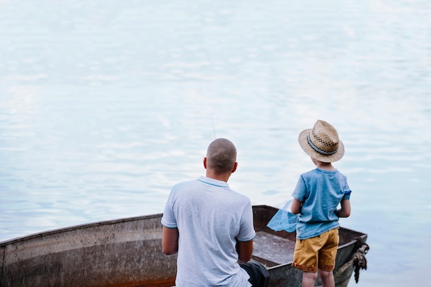 Foto gratuita ragazzo con suo padre pesca sul lago