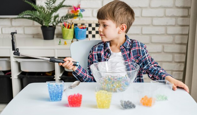 メガネのヒドロゲルボールを持つ少年