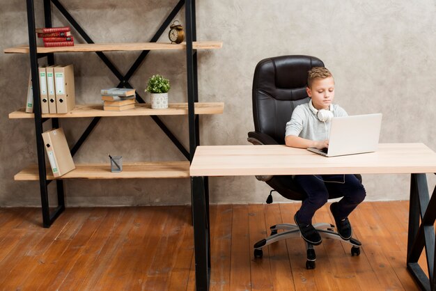 Boy with laptop in office