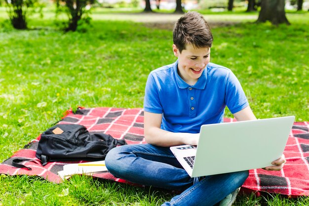 Boy with laptop in the park