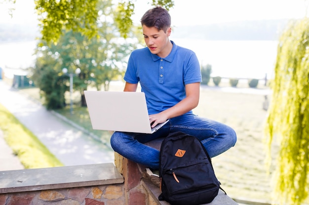 Free photo boy with laptop in park