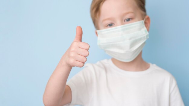 Boy with mask showing ok sign