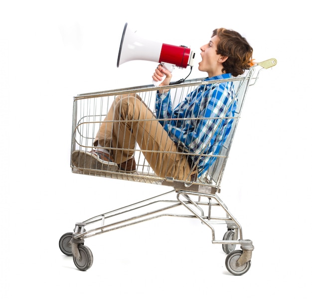 Free photo boy with a megaphone in a shopping cart