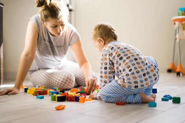 カラフルな建物のキットで遊んでいるママと少年