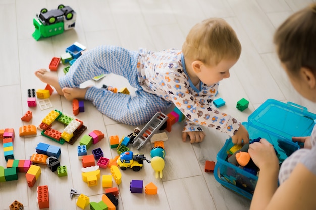 Foto gratuita ragazzo con la mamma che gioca in kit di costruzione colorato