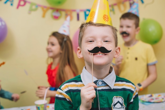 無料写真 誕生日パーティーの紙ひげを持つ男の子