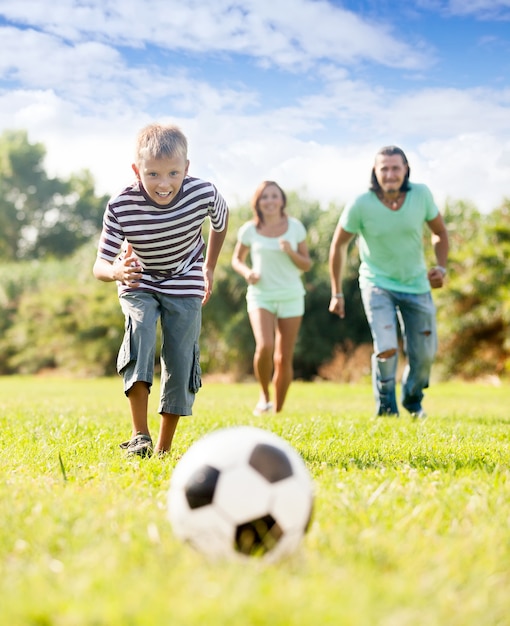 boy with parents playing with soccer ball