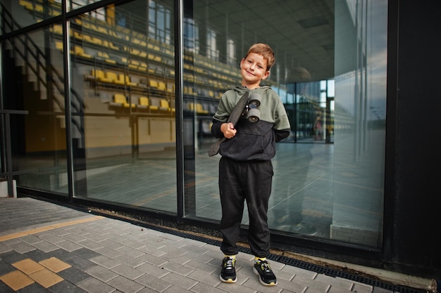 Boy with penny board in hands at stadium