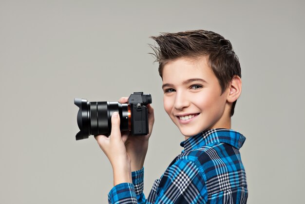 Boy with photo camera taking pictures. Portrait of the caucasian boy  with digital camera in hands