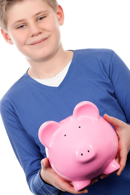 Boy with pink piggybank on white space