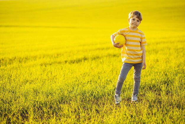 Boy with soccer ball in the meadow