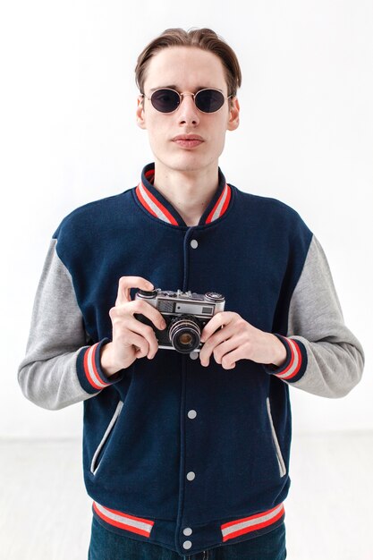 Boy with sunglasses holding camera