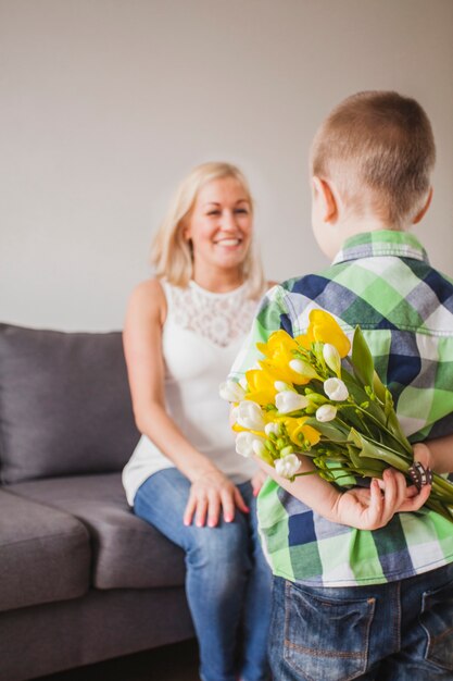 彼の母親のための驚きの贈り物を持つ少年