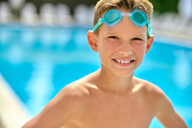 Мальчик в плавательных очках смотрит в камеру