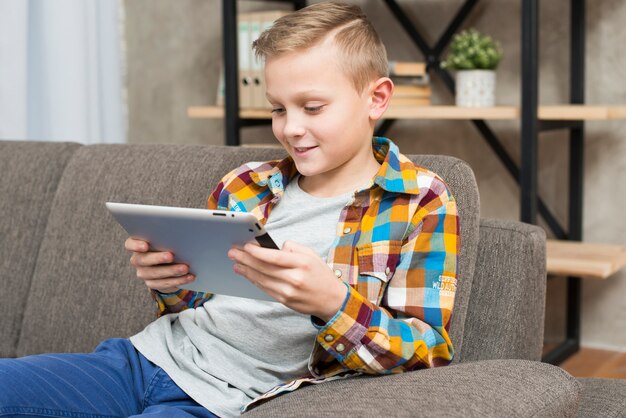 Boy with tablet on couch