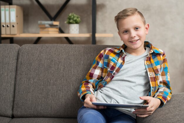 Boy with tablet on couch