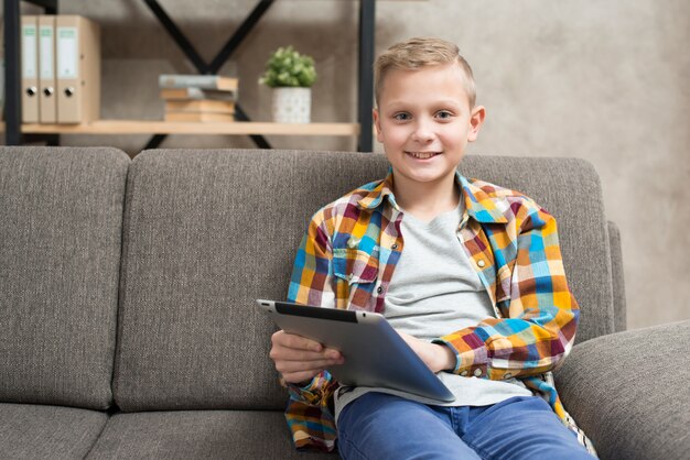 Boy with tablet on couch