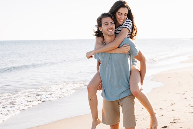 Boyfriend carrying girlfriend at the sea