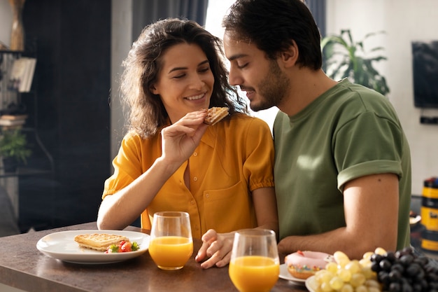 Boyfriend and girlfriend eating waffles together at home