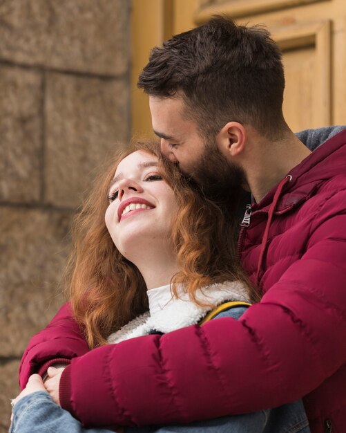 幸せなガールフレンドにキスのボーイフレンドをクローズアップ