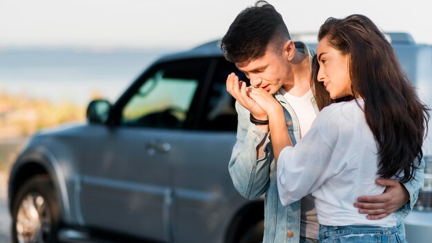 彼氏のガールフレンドの手ぼやけ車にキスのボーイフレンド