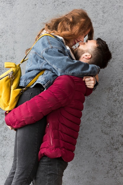 Ragazzo che alza la sua ragazza felice