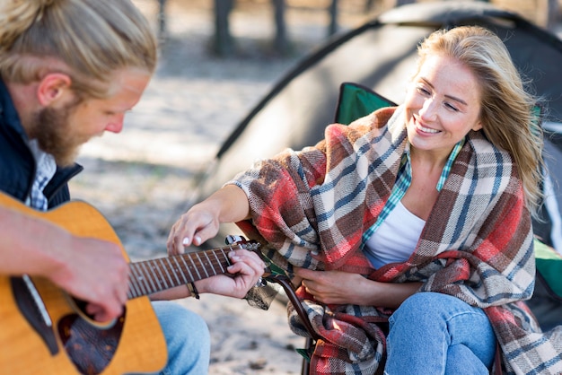 Free photo boyfriend playing acoustic guitar side view