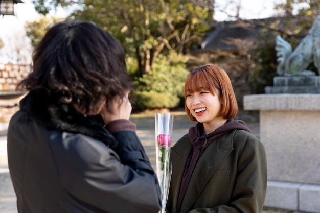 Boyfriend surprising girlfriend with a rose on white day