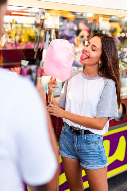 Boyfriend taking photo of girlfriend eating cotton candy