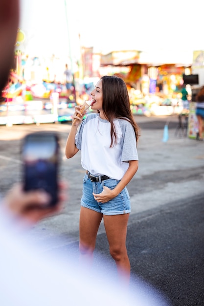 アイスクリームを食べているガールフレンドのボーイフレンド撮影写真