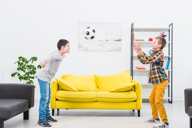 Boys playing football in living room