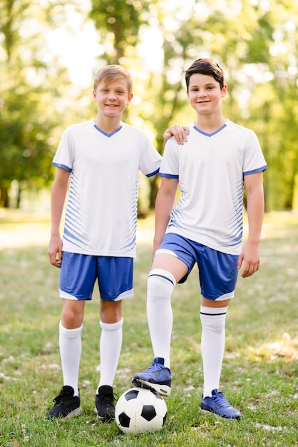 Foto gratuita ragazzi in posa con un calcio all'aperto