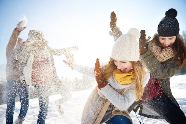 男の子が女の子に雪玉を投げる