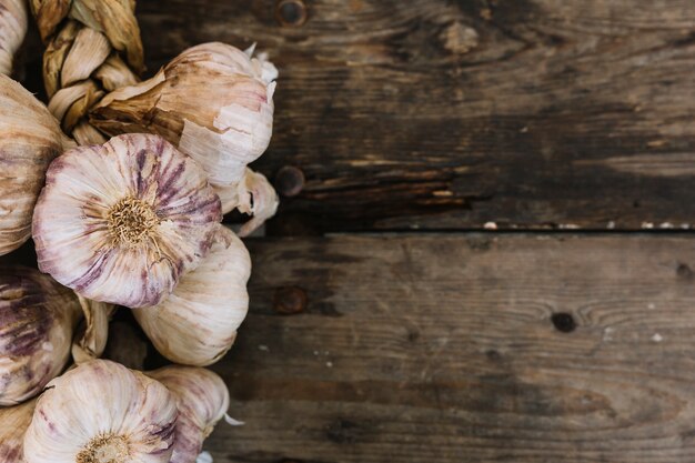 Braid garlic bulbs on wooden textured backdrop