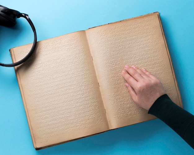 Libro Braille su sfondo blu piatto laici