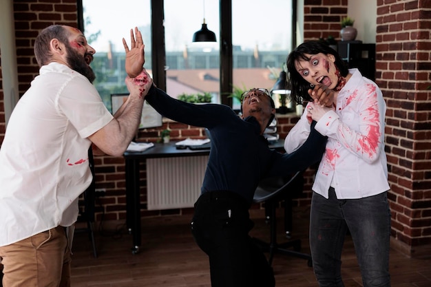 Brain eating zombies chasing frightened man in business office, looking dangerous and creepy. Spooky evil monsters attacking person to kill, having bloody scars and wounds, being aggressive.