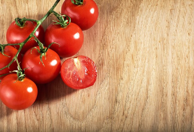 Free photo branch of red cherry tomatoes organic wooden.