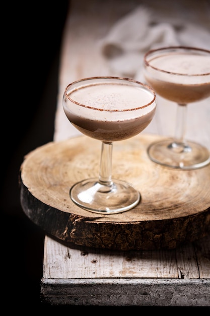 Brandy Alexander cocktail on wooden table and black background